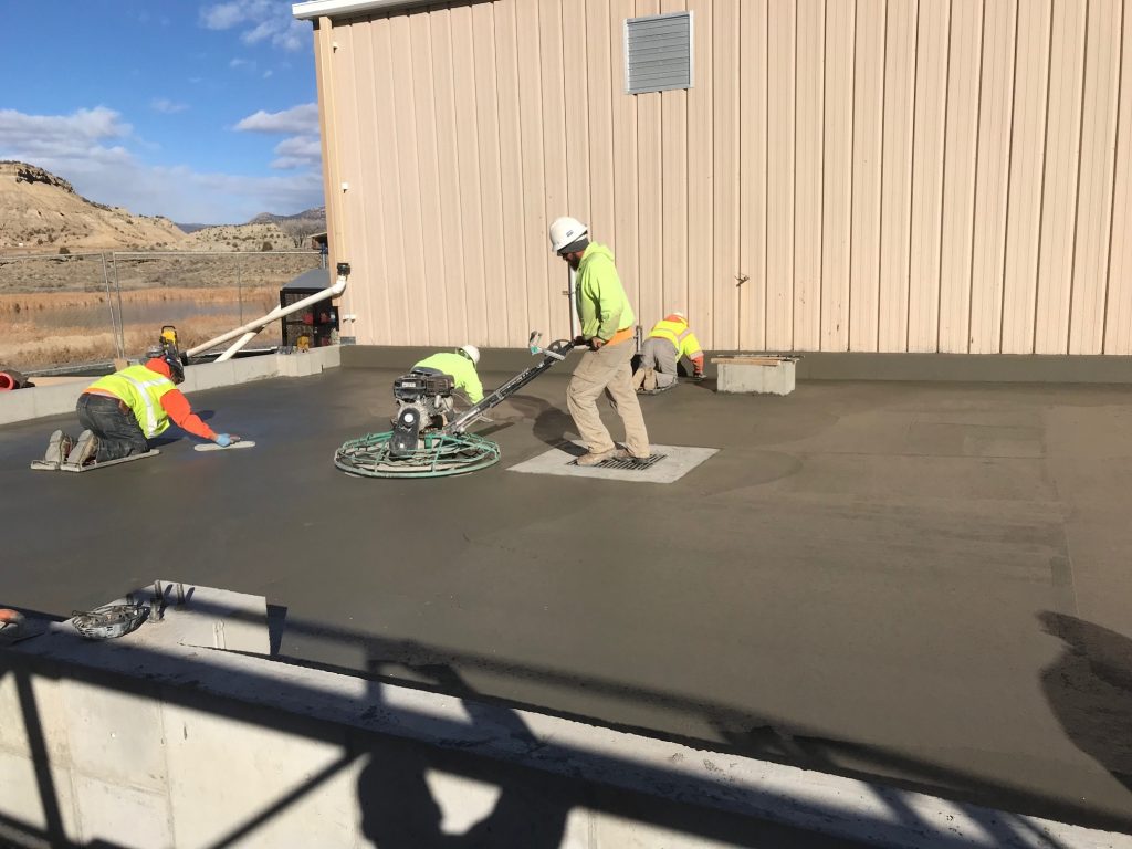 Smoothing out the concrete for the metal building foundation